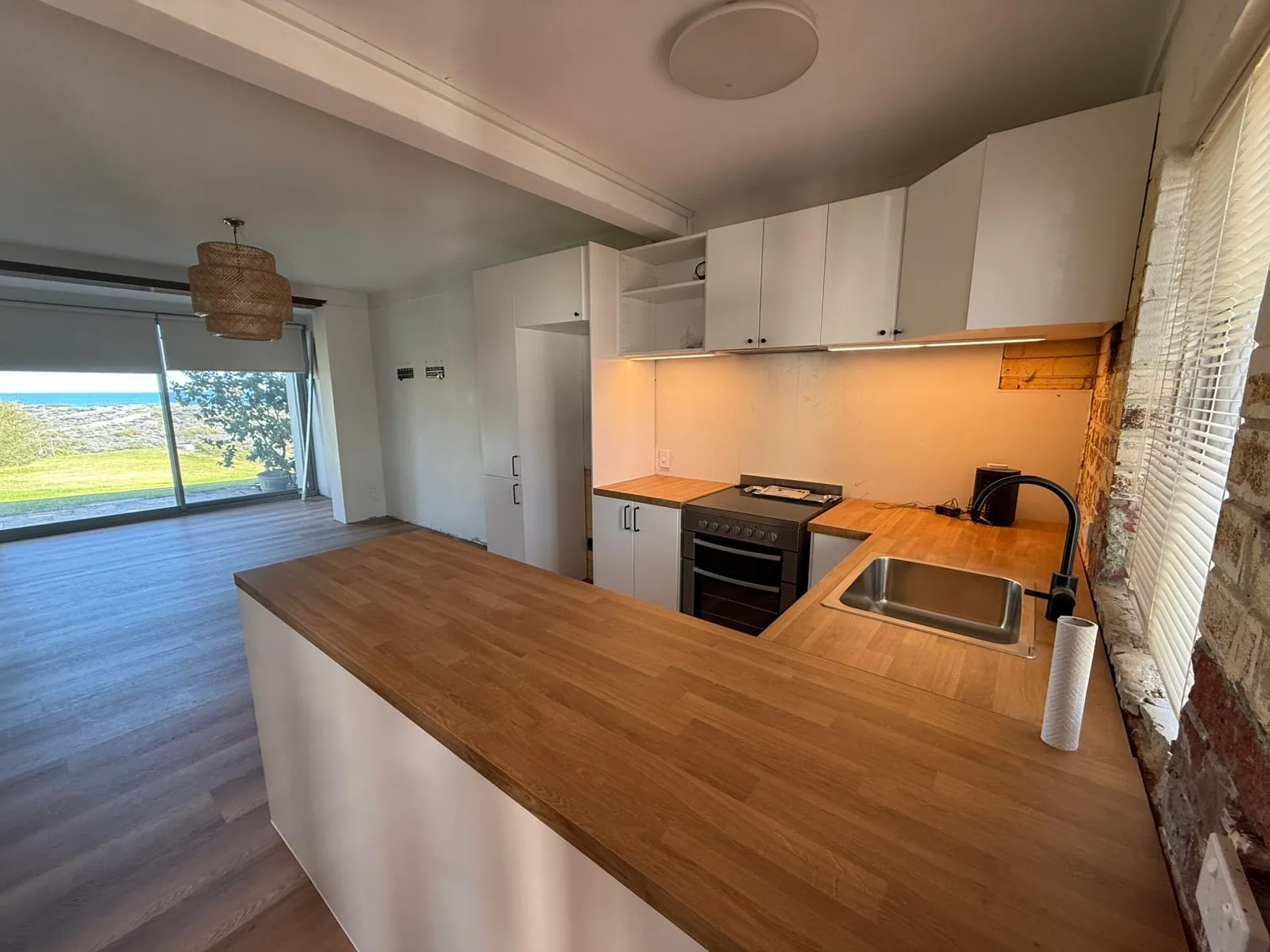 Coastal kitchen refresh with white cabinetry and timber benchtops