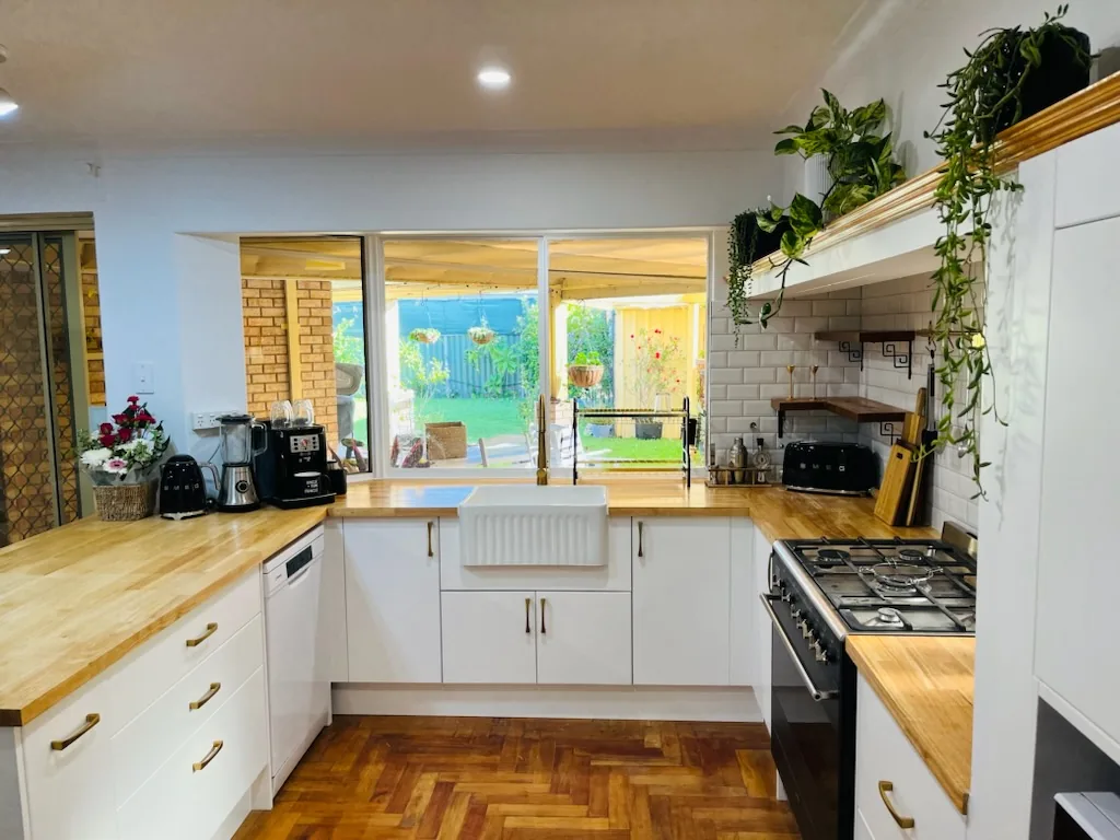 Farmhouse kitchen finish with timber counters and white cabinetry