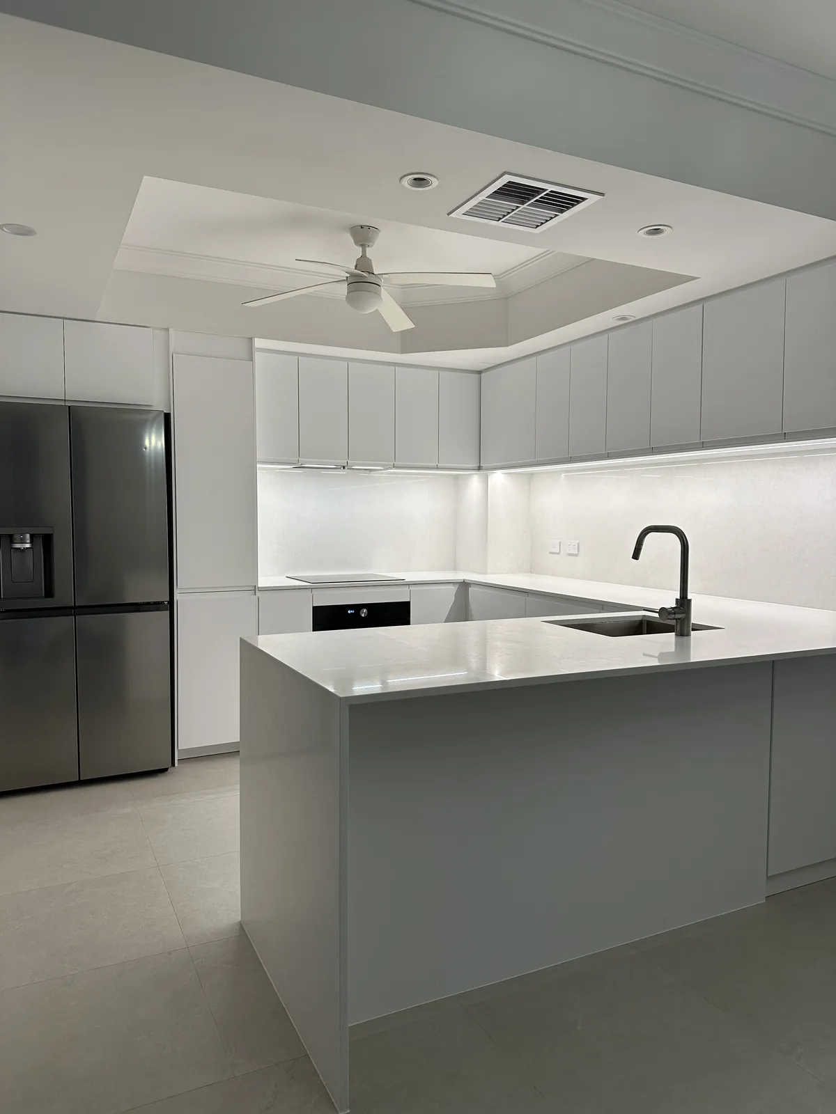 Minimalist family kitchen renovation with peninsula bench and neutral finishes