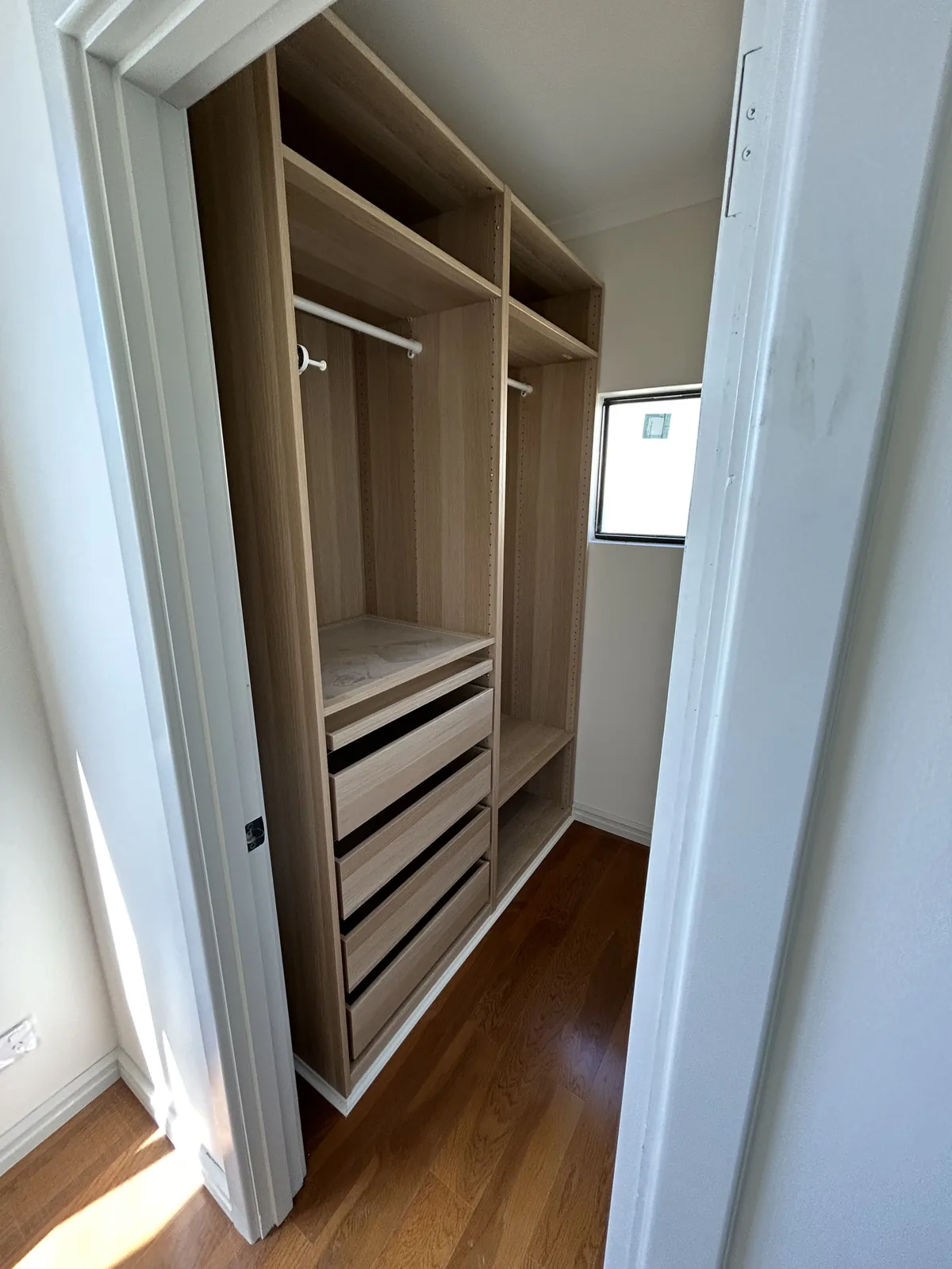 Custom timber walk-in robe joinery with drawers and open hanging storage